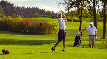 Golfer taking a swing on golf course